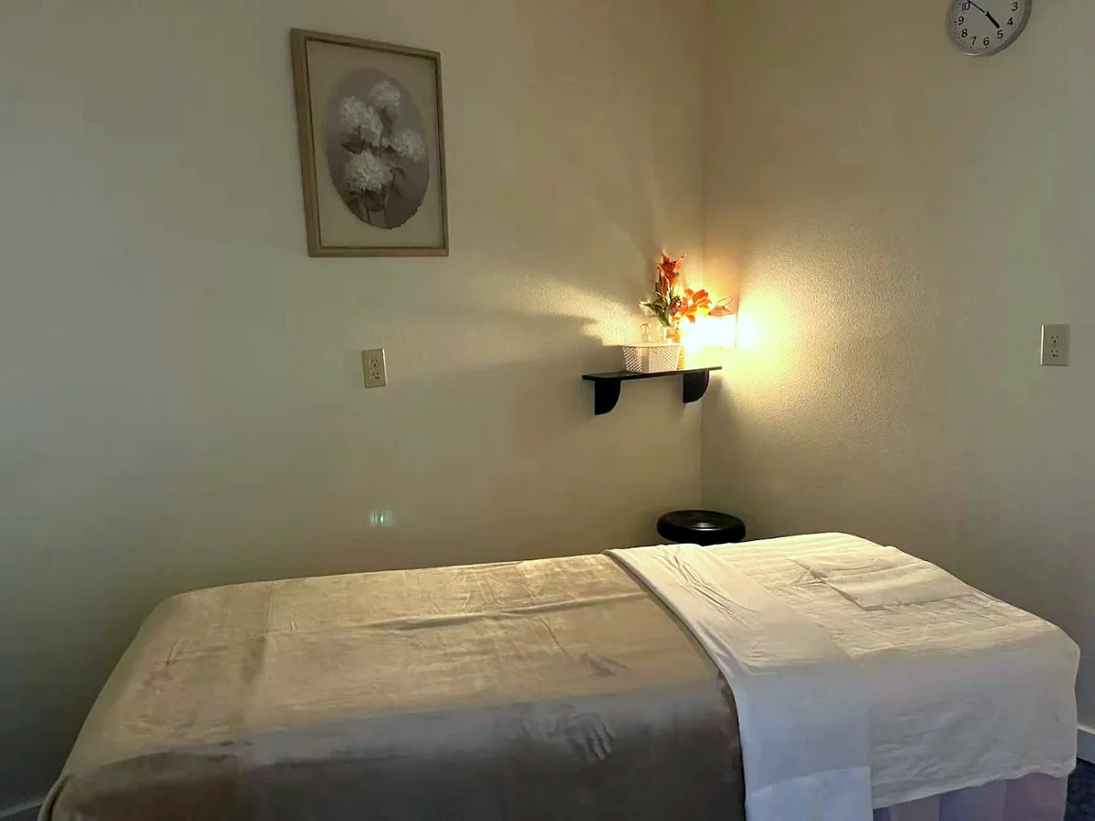 Massage room at the Forest Grove, Oregon studio lit by a single warm lantern
