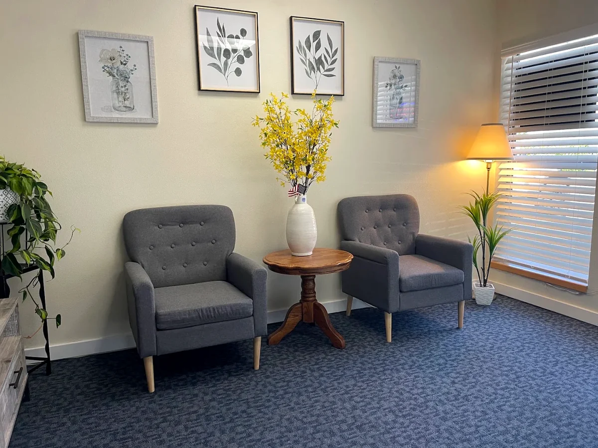 Waiting area of the West Valley Massage studio in Forest Grove, Oregon, with two armchairs, plants and a window